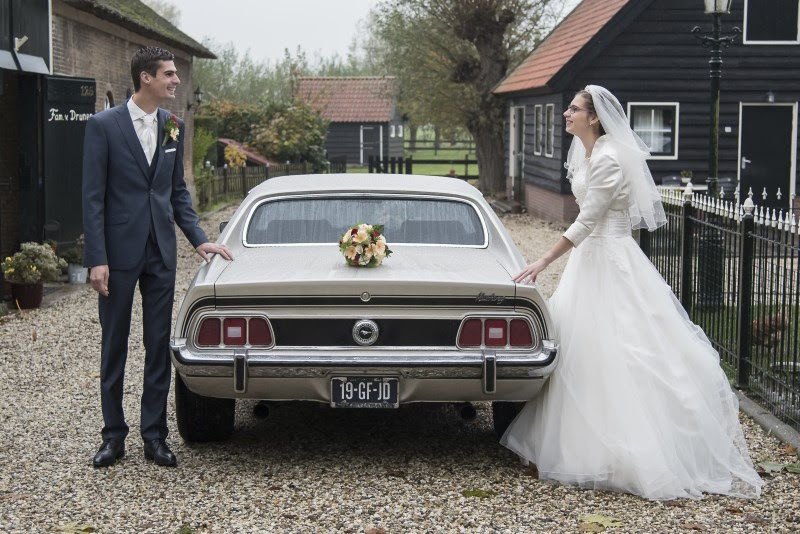 Ford Mustang trouwauto met bruid en bruidegom bij trouwlocatie