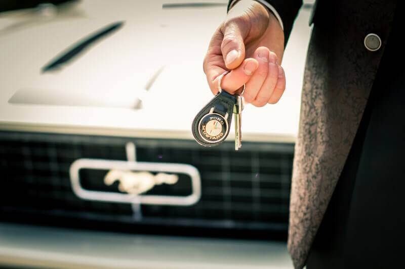 Sleuteloverdracht van klassieke Ford Mustang voor trouwdag